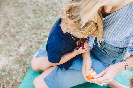 年轻姑娘和可爱的小儿子在夏日野餐上放松图片