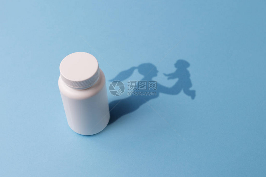 有片剂的塑料瓶和一个有孩子的女孩形式的阴影集中受孕机会的图片