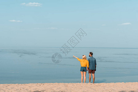 一对在海滩握手的情侣女友图片