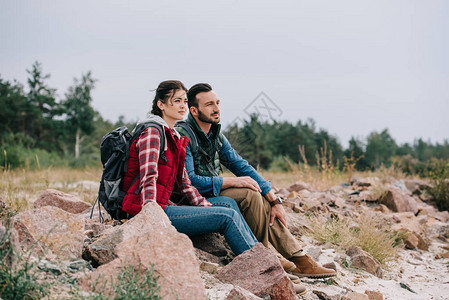 旅途中的夫妻两人坐在石头上休息图片