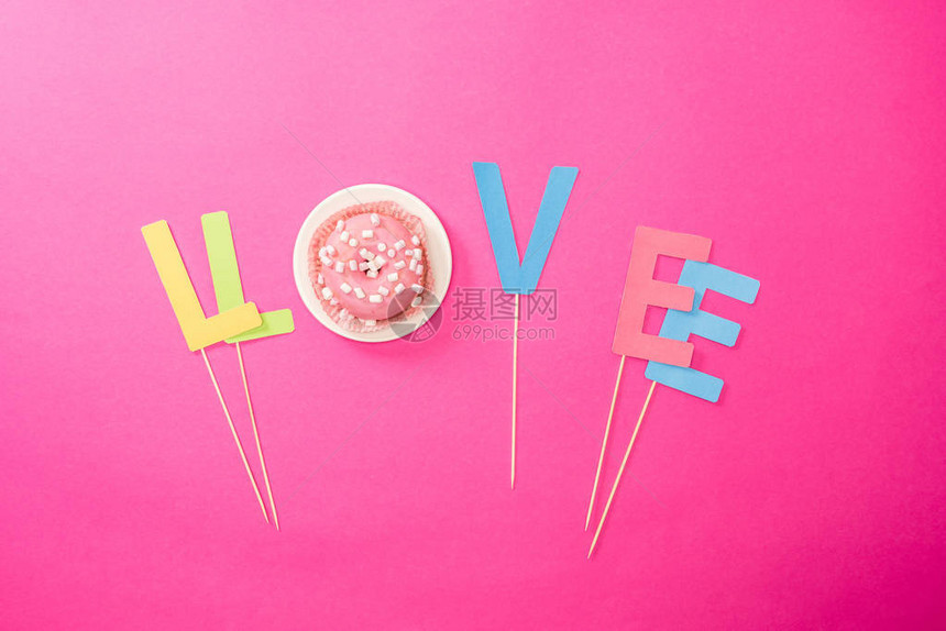 爱的顶端景色符号来自粉红色甜圈上的信和奶油霜图片
