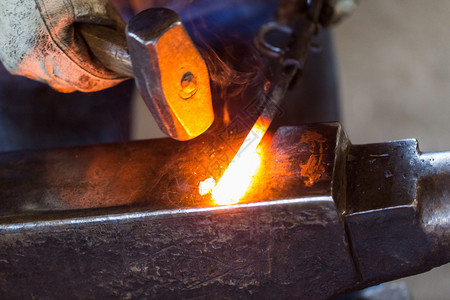 铁匠在铁砧上锻造热铁高清图片
