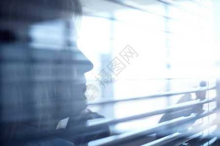 女和办公室百叶窗轮廓的特写镜头图片