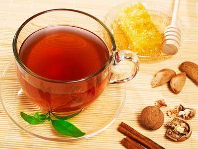 一杯茶配肉桂蜂蜜和坚果用白色隔开图片