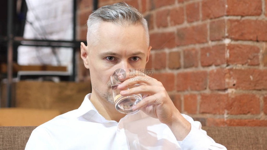 中年男子喝水的肖像图片