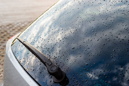 一辆银色汽车在后黑窗上的雨滴后面有图片