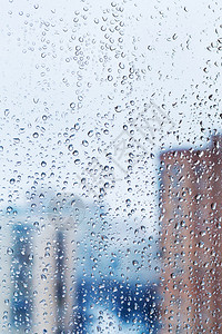 玻璃窗上的雨滴有冬季城图片