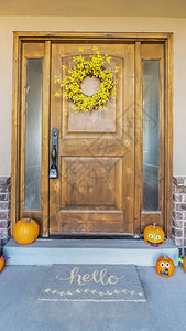 在房子门口的垂直万圣节装饰花圈和胡萝卜图片