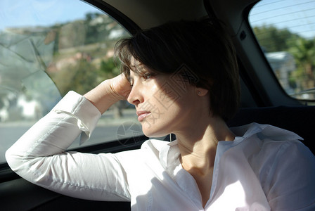 坐在车后座的女人望着窗外图片