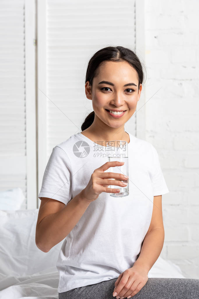 穿着白色T恤衫的亚洲女孩带着微笑坐图片