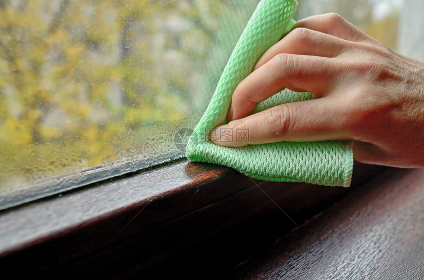 女人清洁窗户上的冷凝水图片