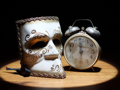狂欢节面具和破旧闹钟背景图片