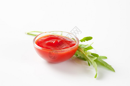 一小碗番茄酱和芝麻菜叶图片