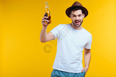戴着帽子的快乐青年男子拿着玻璃瓶夏季饮料笑着在摄像机上微图片