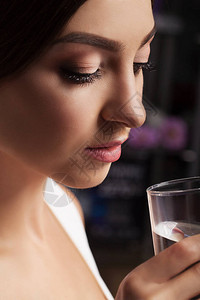喝水女孩从玻璃杯里喝水干净的水健康的生活方式健康的概念在图片