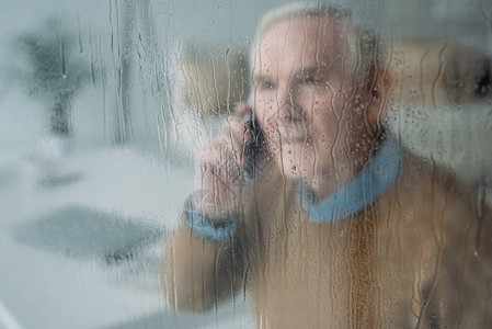 在雨玻璃后面高年长的骚扰图片