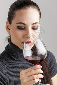 年轻女子喝红酒的肖像图片
