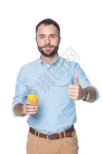 男人拿着杯子橙汁并显示拇指在图片