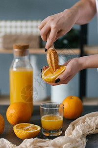 女人手挤新鲜橙汁的近景图片