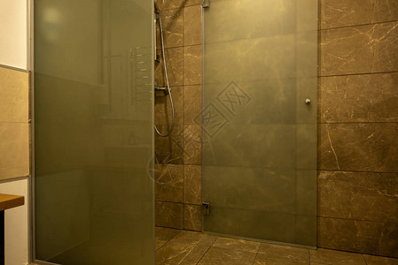 带棕色瓷砖和玻璃淋浴间的浴室内部图片