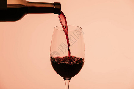 红酒从瓶中倒入玻璃在图片
