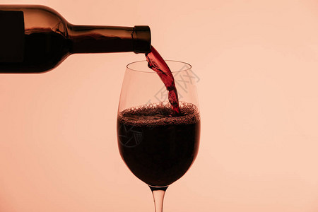 红酒从瓶中倒入玻璃在图片
