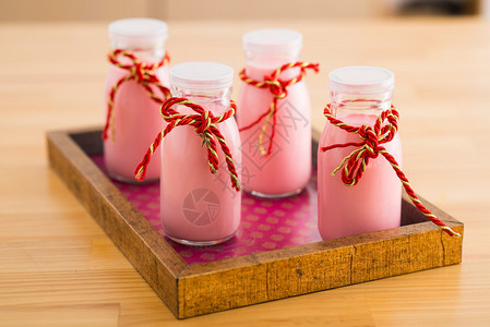 装饰玻璃瓶中的粉红色自制酸奶图片