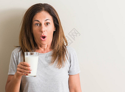 中年妇女喝着一杯鲜牛奶惊恐万状图片