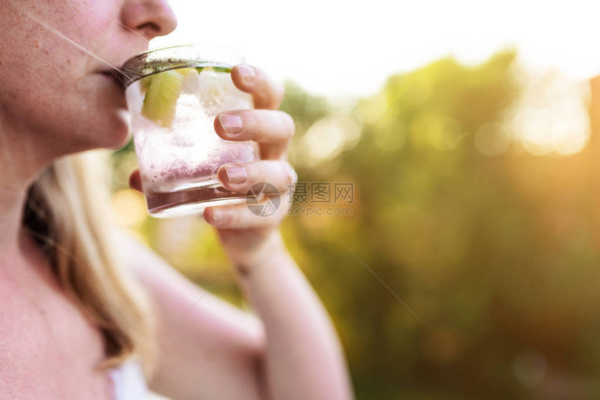 夏日户外金发女郎喝冰饮料的特写镜头图片