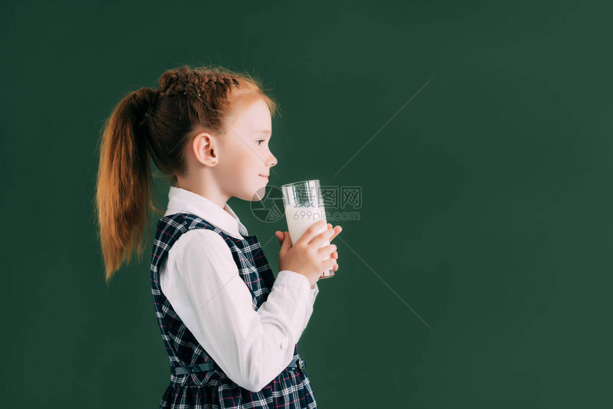 一边是微笑的小女学生在黑板附近站着时拿着牛图片