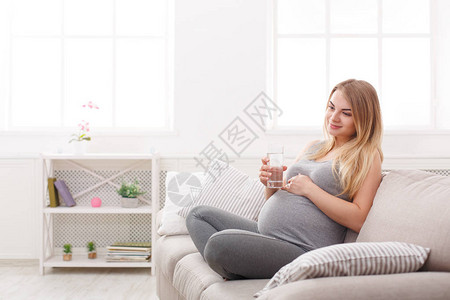 孕妇在沙发上坐着一杯水图片