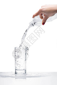 妇女用白色隔着的塑料瓶倒入玻璃中的水将图片