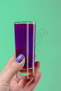 以紫色鸡尾酒与绿松石隔离的女人用玻璃图片