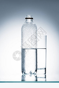 反射面上的塑料瓶和水杯图片