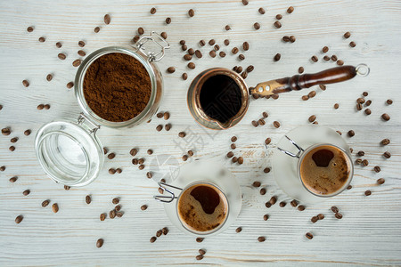 两杯咖啡咖啡豆和木背景上的土耳其人图片