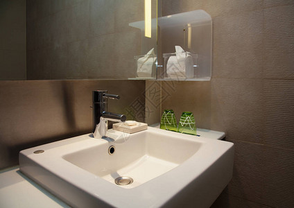 现代洗手间有钢水龙头和正方白色水槽在图片