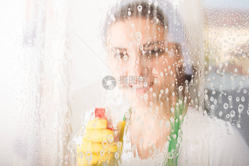 女清洁女工或家庭主妇用喷雾洗窗图片