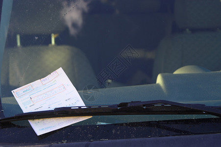 一张爱车罚单被放在挡风玻璃底部的高清图片