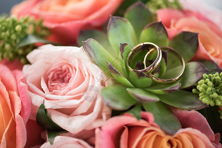 花束上两个金结婚戒指玫瑰和香肠结婚戒图片