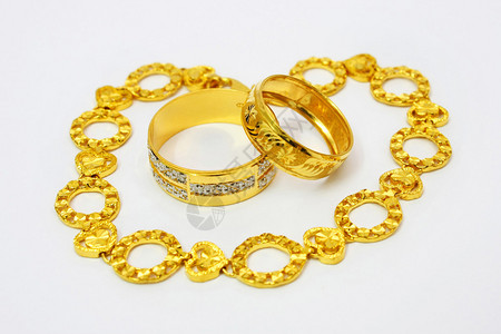 金色的情侣戒指环绕着金色的手镯图片