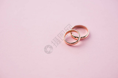 粉红色的结婚戒指婚礼戒指背背景图片