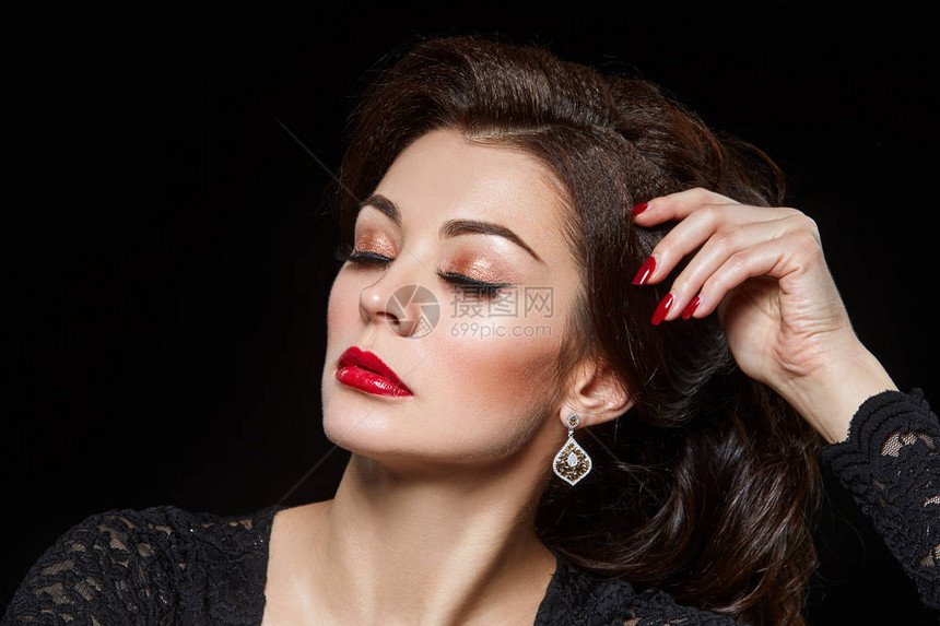 穿黑裙子的红嘴唇和花哨发型美丽的年轻美女黑色背景的摄影棚美容图片
