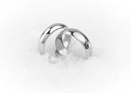 雪地中的一对白金或铂金结婚戒指背景图片