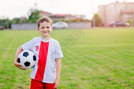 8岁男孩儿童在球场上足球比赛中玩橄榄球图片