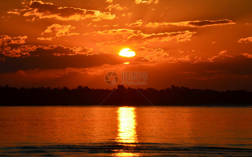 澳大利亚Botany湾水面反射的云后橙色太阳图片