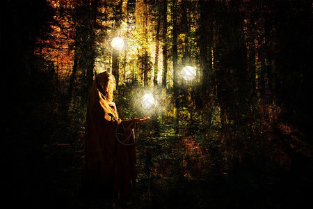 幻想的场景一个戴帽子的女人在森林里带着光球高清图片
