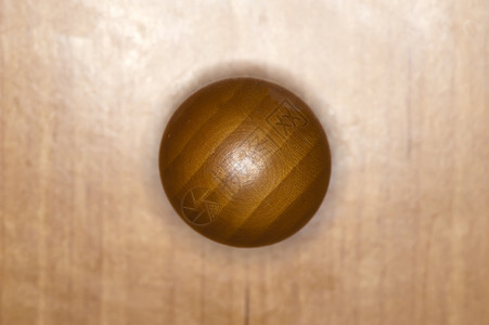 木制背景上的球形木柜旋钮背景图片