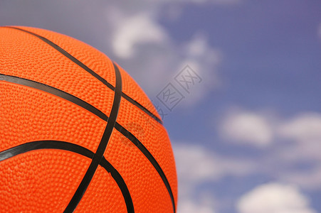 反对多云天空的橙色篮球图片