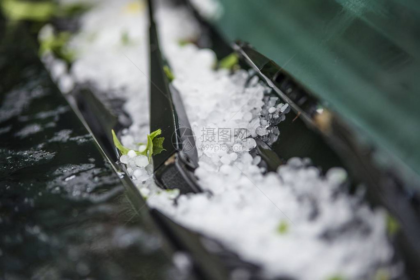 夏季暴风雨过后汽车引擎盖上的大冰雹球图片