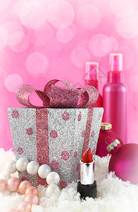 圣诞礼物雪和粉红色背景的美容产品图片
